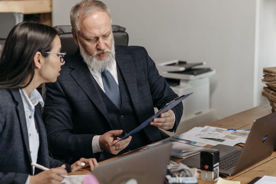Two UK accountants reviewing financial documents together in an office