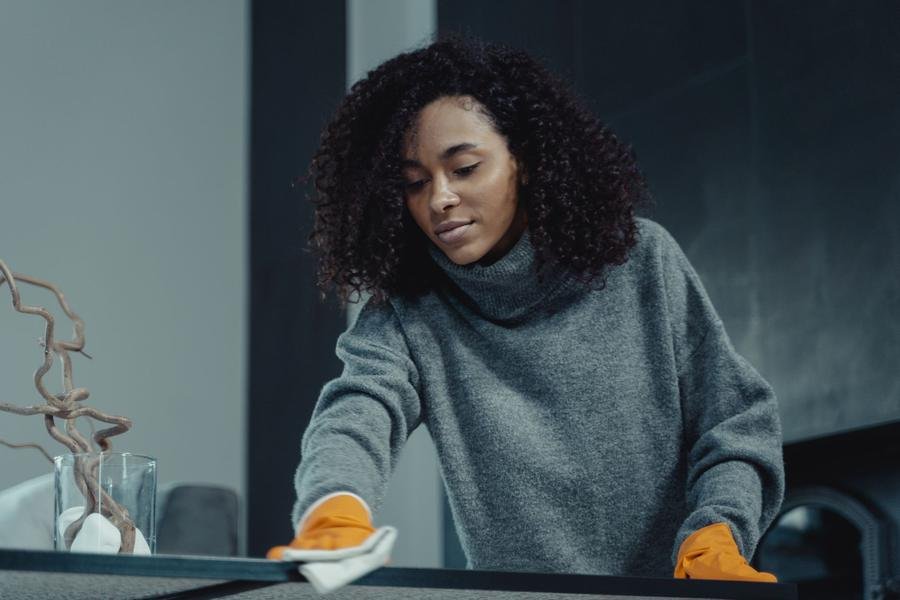 Professional cleaner wiping down a table in a modern home