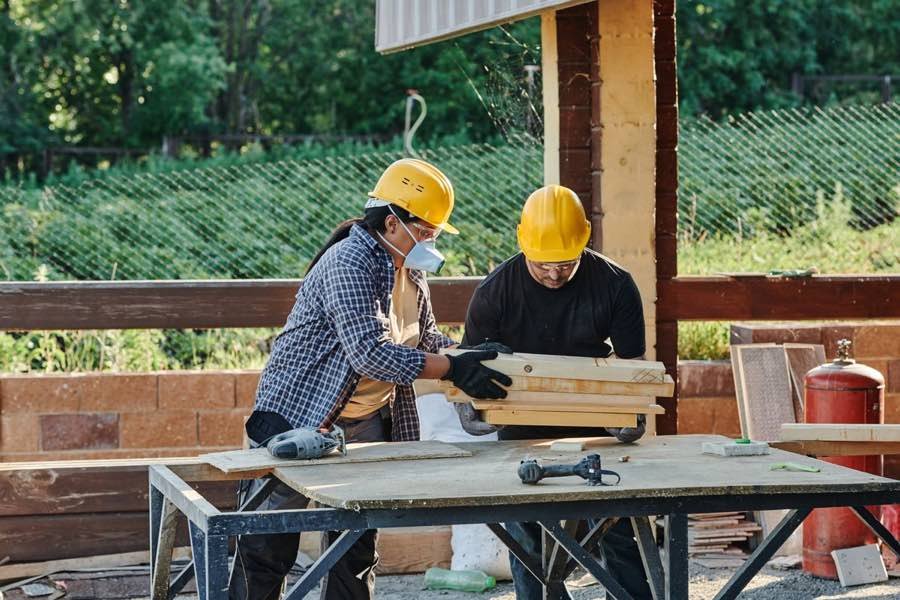 Two UK builders working together on a construction site