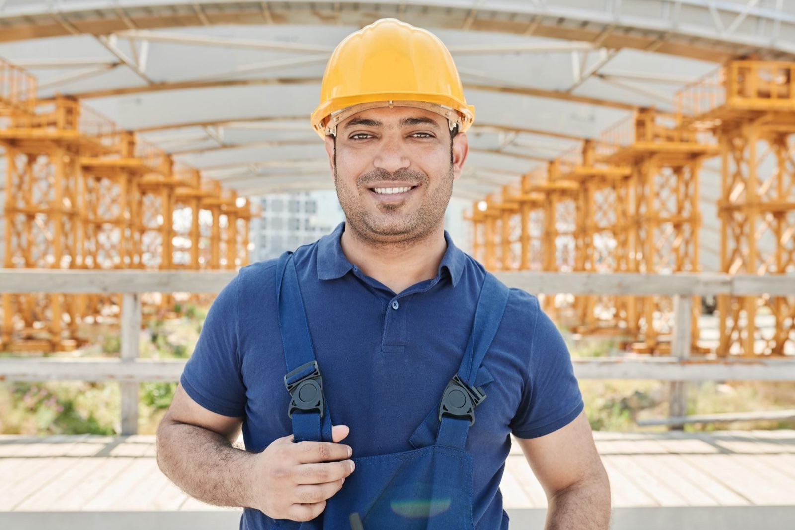 UK builder in a hard hat smiling on a construction site