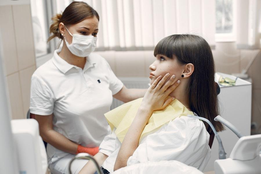 Dentist examining a smiling patient in a dental surgery
