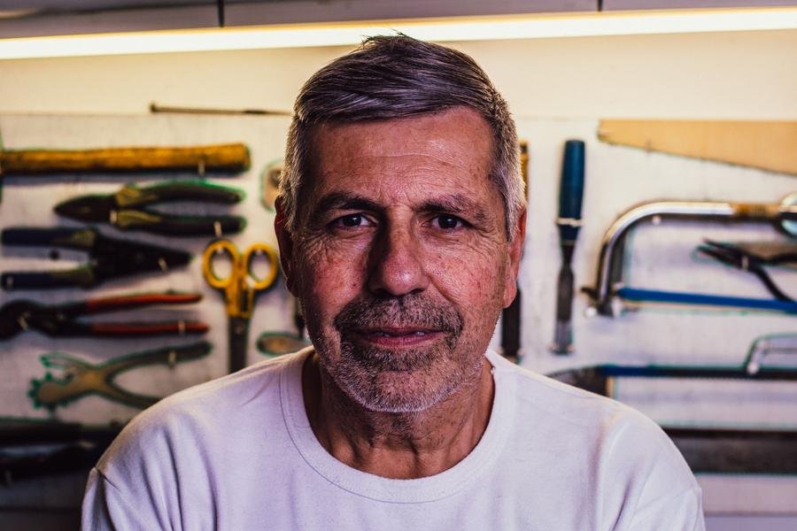 Experienced UK glazier in his workshop surrounded by tools