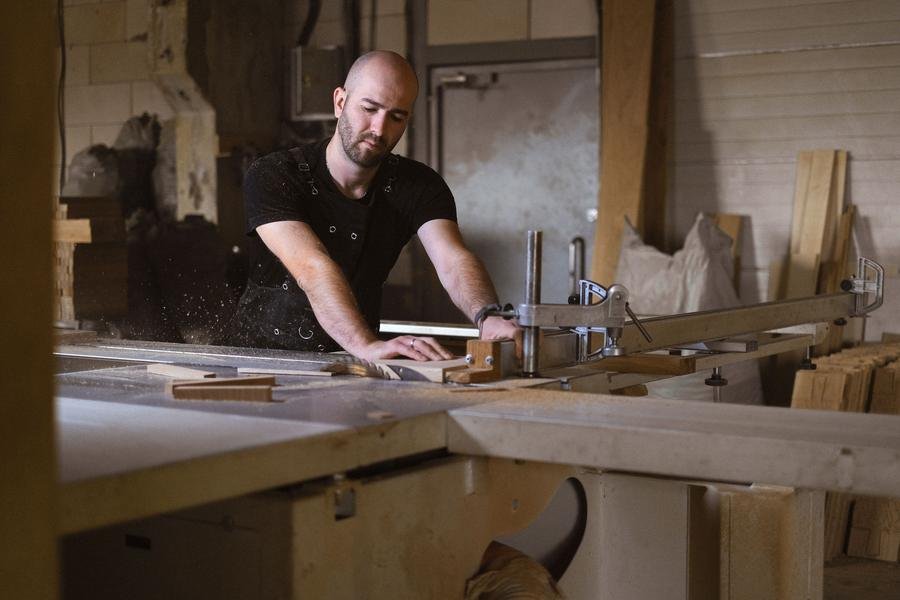 UK joiner working at a table saw in his workshop