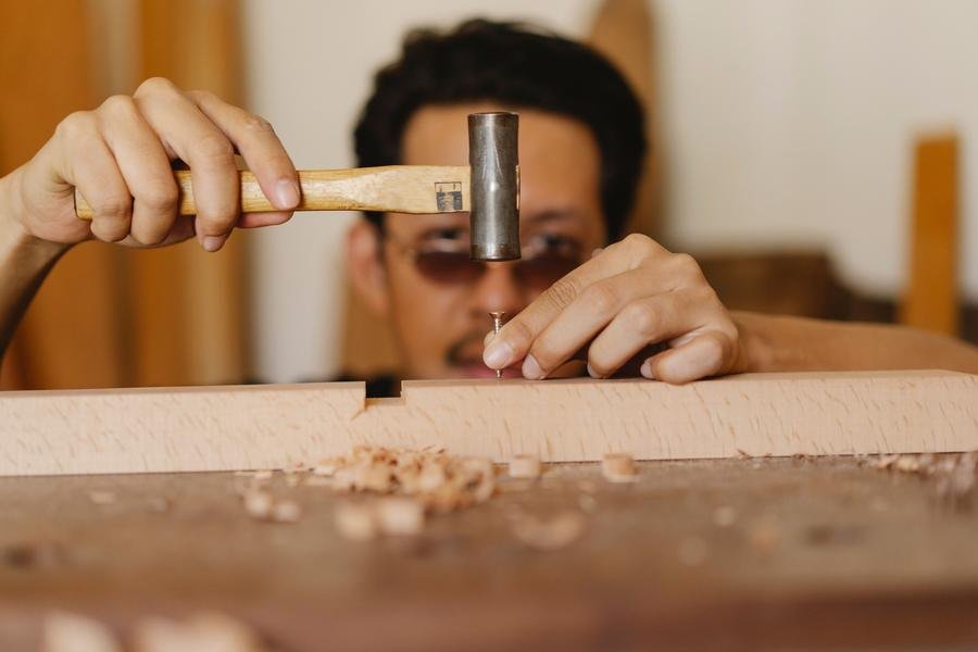 UK joiner shaping timber with a mallet and chisel