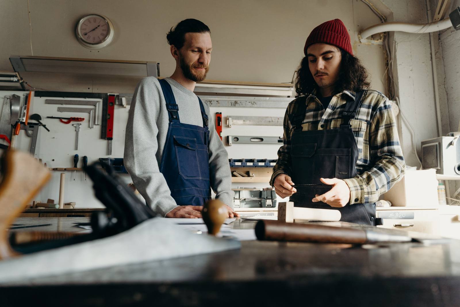 UK joiner and carpenter working together in a woodwork workshop