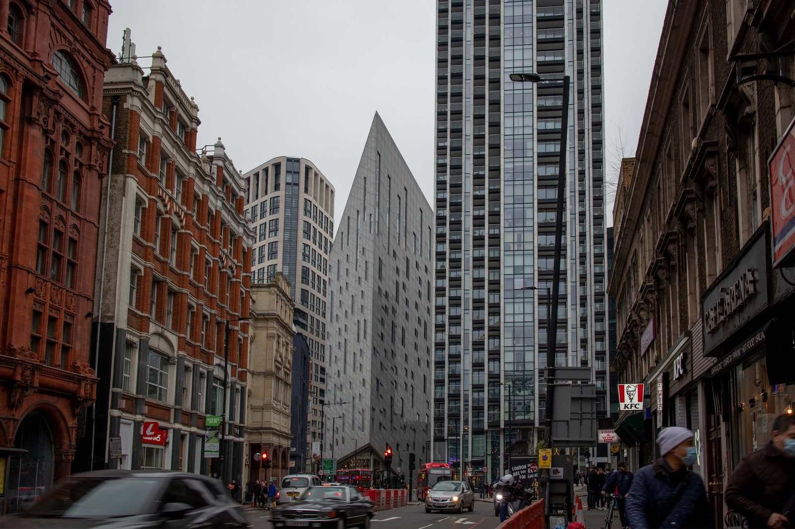 London high street with red bus and black cab on an overcast day