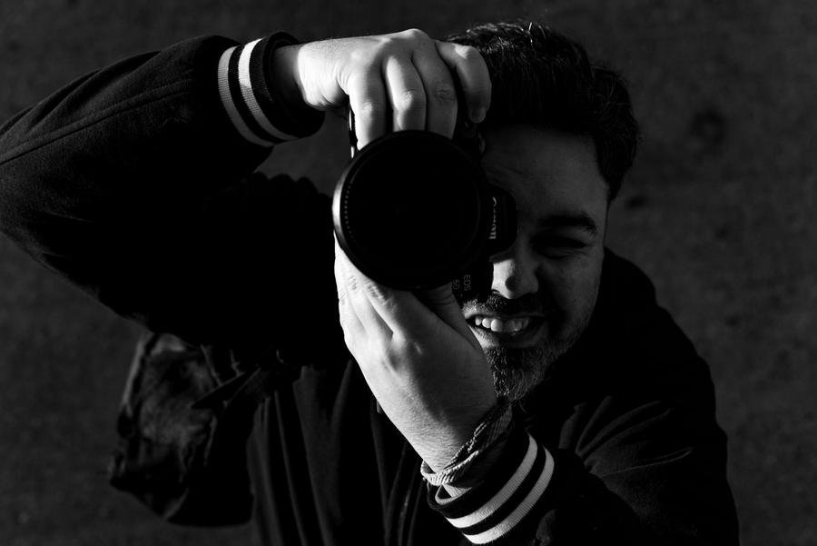Wedding photographer smiling behind the camera on a UK shoot