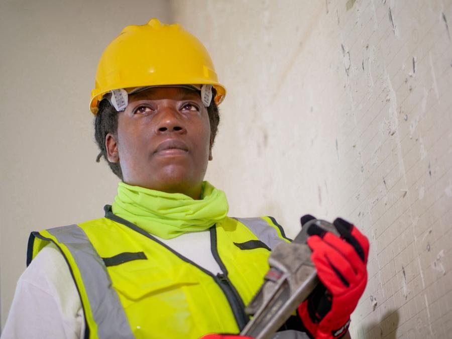 UK plumber holding a pipe wrench