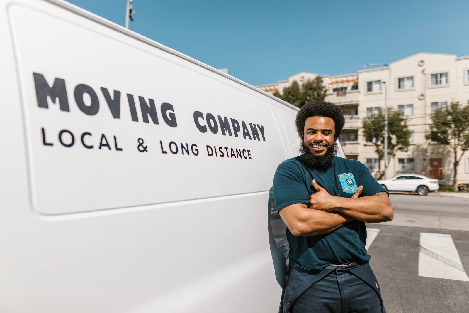 UK removals worker smiling beside a moving van