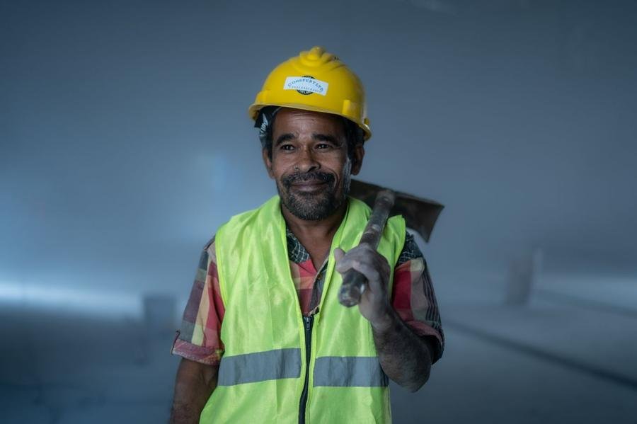 UK roofer in a hi-vis vest smiling on site