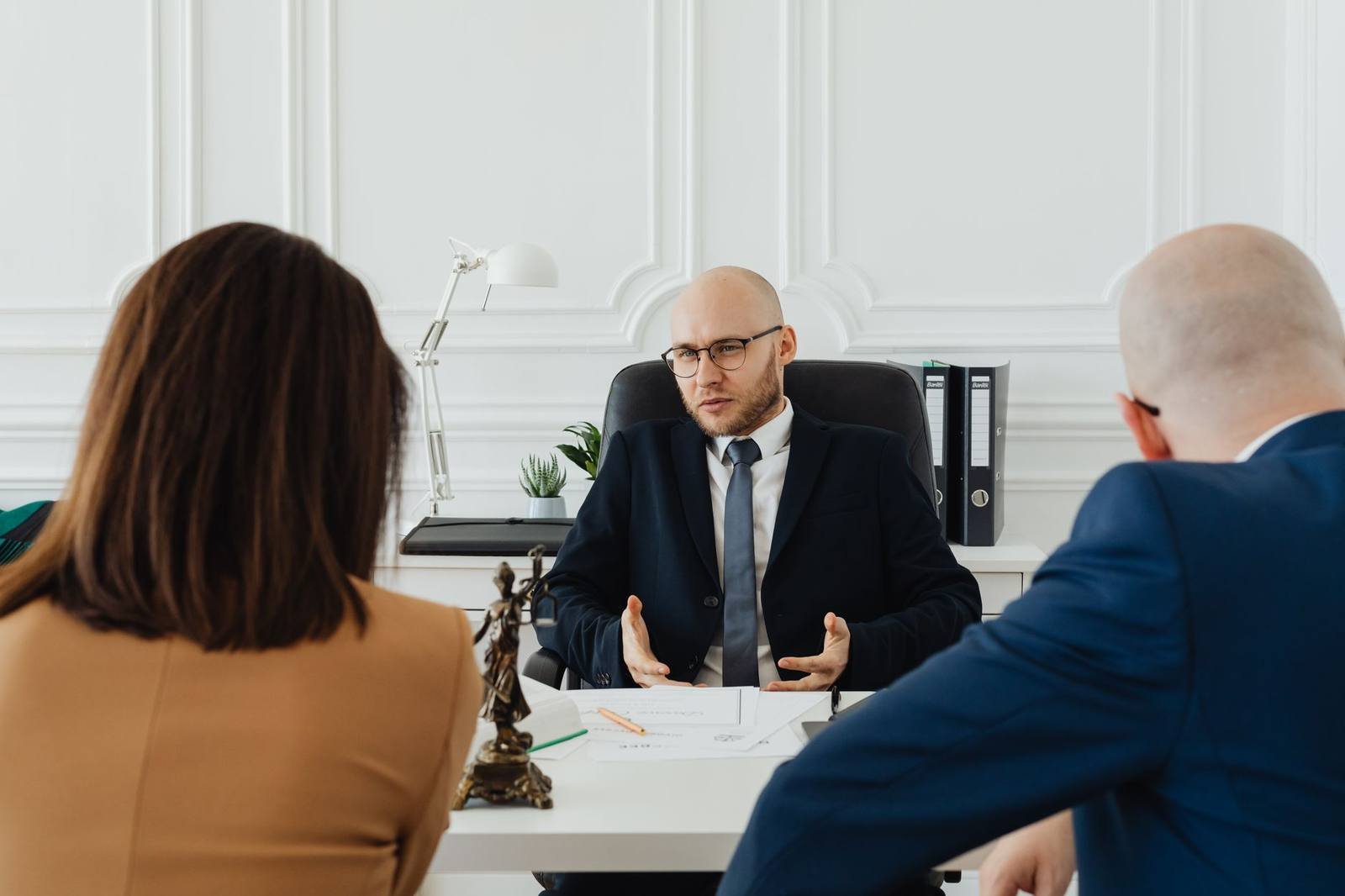 UK solicitor advising clients across a desk in a law office